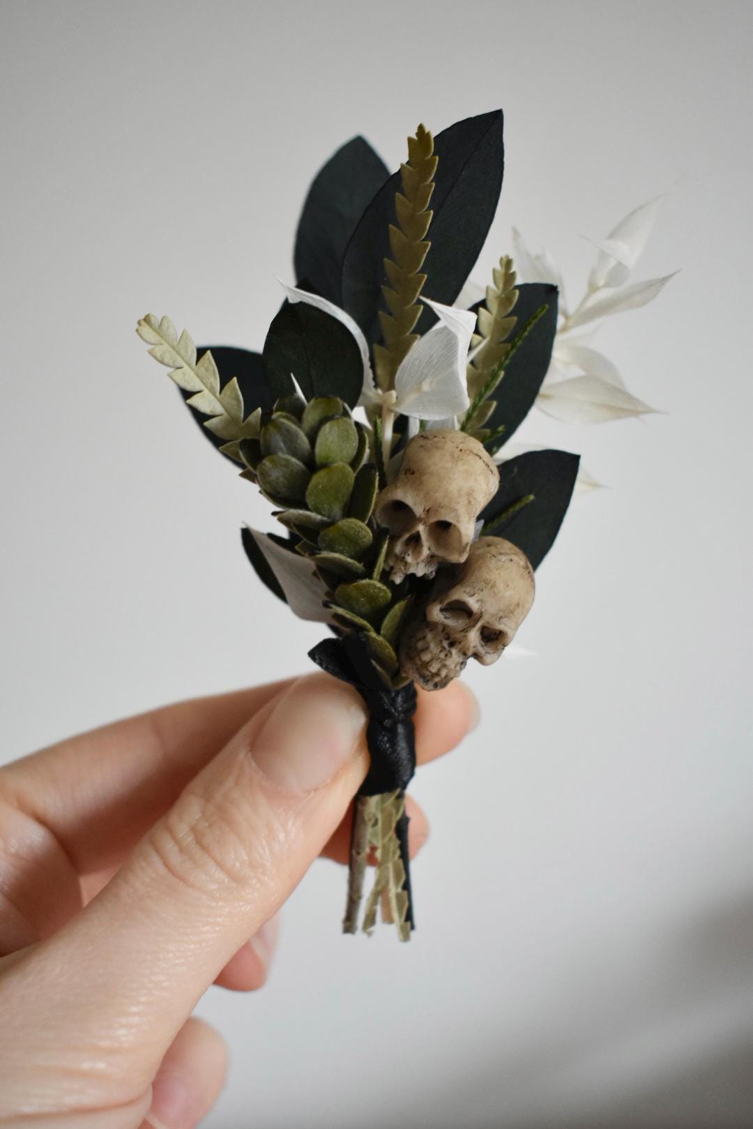 Foliage boutonniere with mini faux skulls