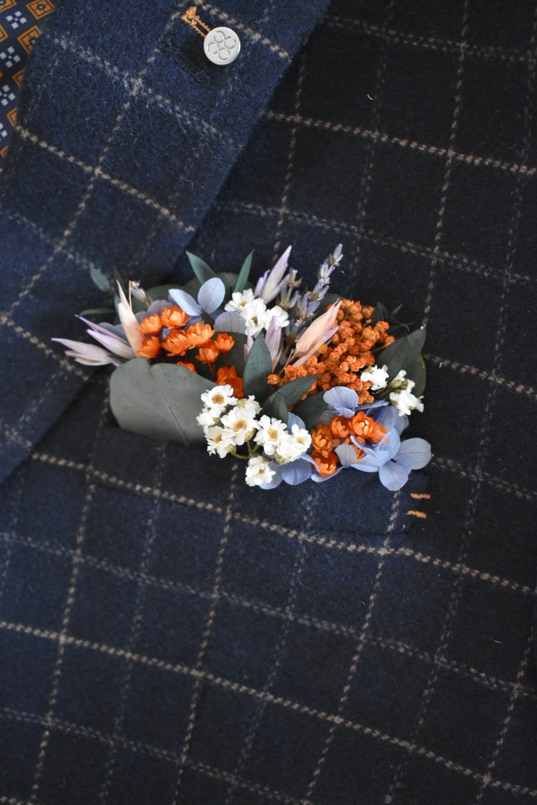 Orange, blue and lilac pocket boutonniere