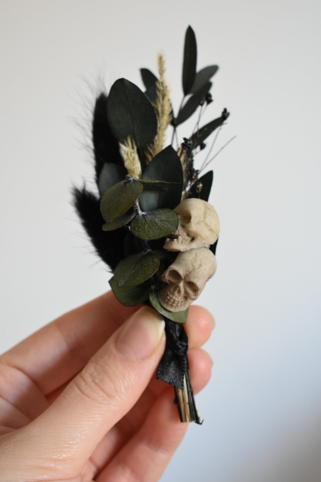 Black dried foliage boutonniere with mini faux skulls